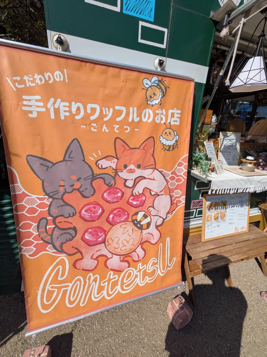 猫とワッフルのイラストが描かれた手作りワッフルのお店ごんてつの看板